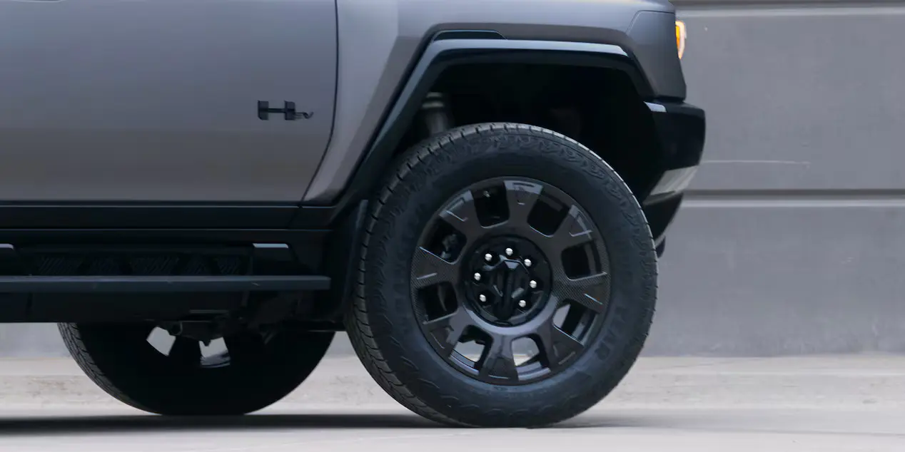 A unique 22-inch carbon fiber black wheels and all-terrain tires on the 2026 Hummer EV